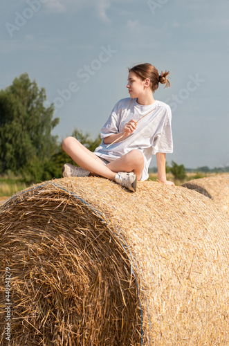 Teenager girl having fun in a wheat field on a summer day.
