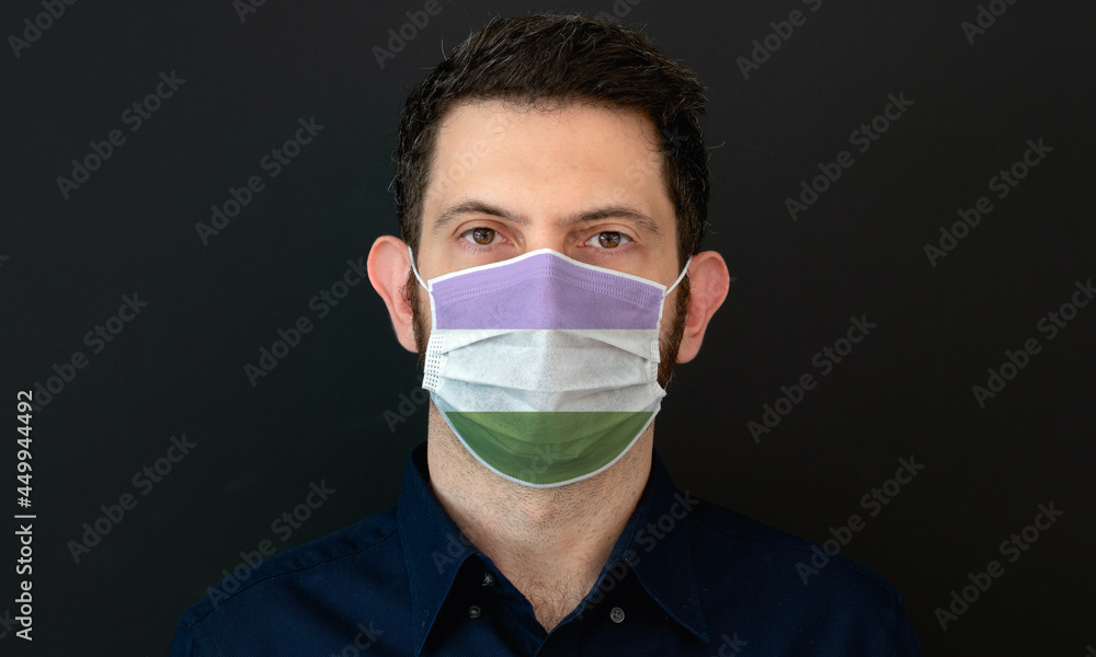 Portrait of an adult man wearing a LGBT genderqueer flag colors facial mask. LGBT gay rights concept with black background. These colors symbolize the genderqueer flag. Portrait of an adult man wearing a LGBT genderqueer flag colors facial mask. LGBT gay rights concept with black background. These colors symbolize the genderqueer flag.