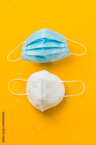 medical protective face masks on vertical yellow background, coronavirus prevention 