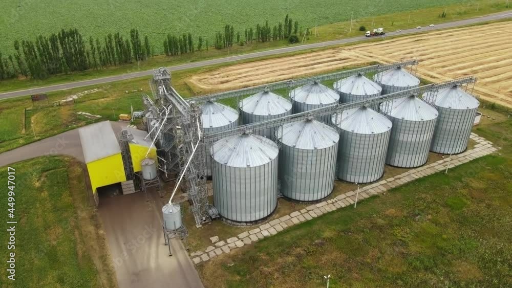Large metal silo for storing grain. Modern industrial plant. Granary. Containers storing agriculture crop. Grain elevators in countryside Large metal silo for storing grain. Modern industrial plant. Granary. Containers storing agriculture crop. Grain elevators in countryside