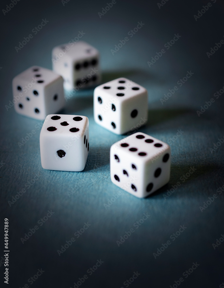 Five dice on a textured teal board. Dramatic edit. Five dice on a textured teal board. Dramatic edit.