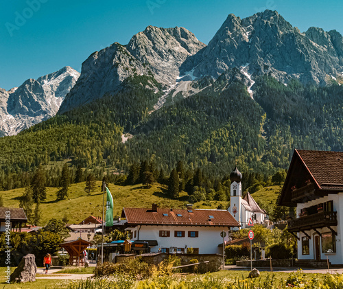 Beautiful alpine summer view with a church and the famous Zugspitze summit in the background at Grainau near Garmisch Partenkirchen, Bavaria, Germany