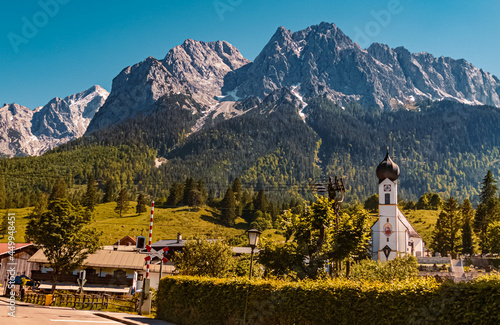 Beautiful alpine summer view with a church and the famous Zugspitze summit in the background at Grainau near Garmisch Partenkirchen, Bavaria, Germany photo