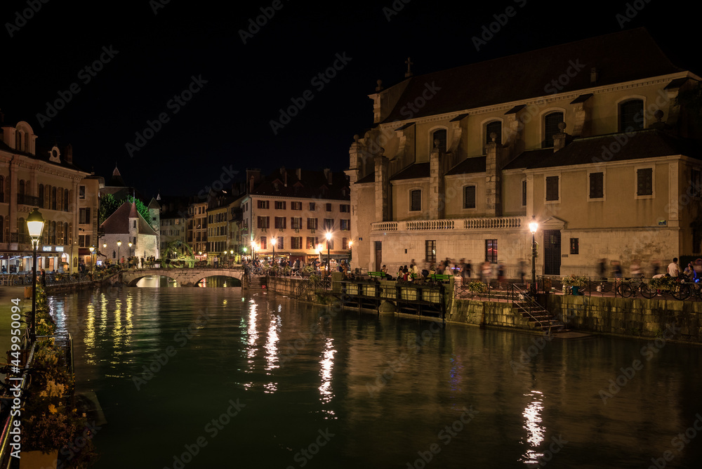 Old town of Annecy city illuminated at night and the reflection of the lights in the water of the canal, France