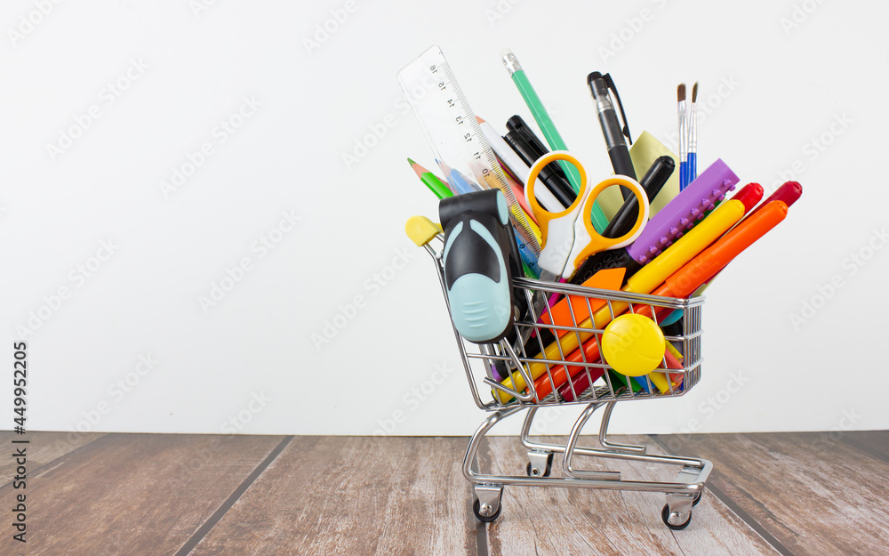 Stationery in a shopping cart. Copy space. Back to school