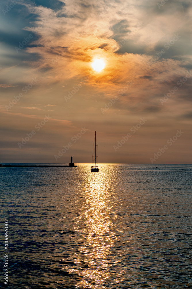Vertical Image of Sunset over Water with Sail Boat at anchor. Vertical Image of Sunset over Water with Sail Boat at anchor.