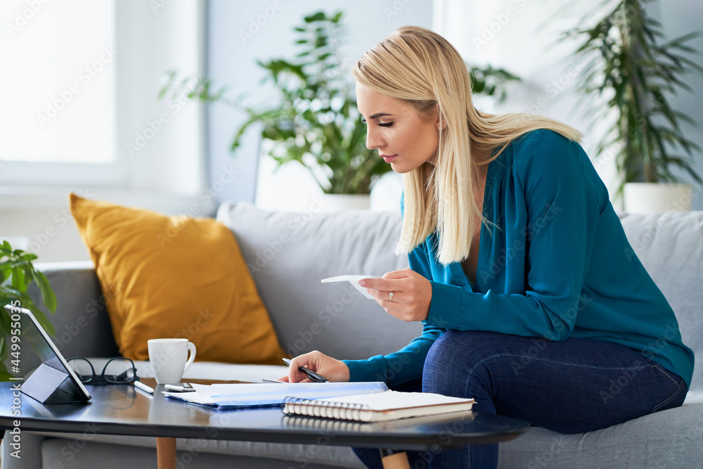 Young woman counting finances, doing paperwork working at home Young woman counting finances, doing paperwork working at home