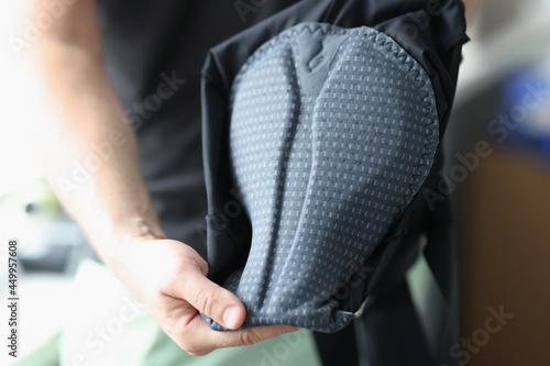 Man shows inside of sportswear for bicycle seat closeup