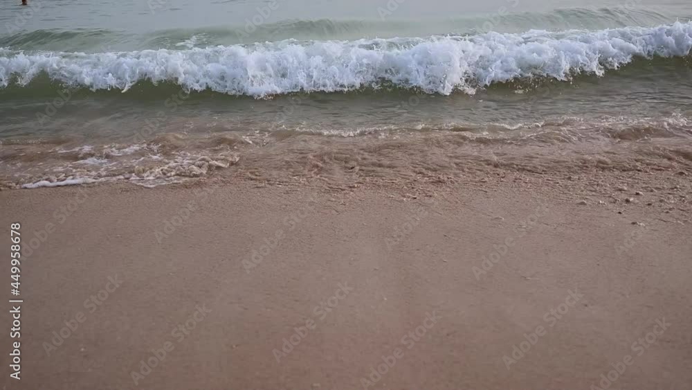 Close-up texture of the surface of a sea or ocean wave that comes to the sandy coast. Natural background with splashes of water and foam. Slow motion vacation summer concept Close-up texture of the surface of a sea or ocean wave that comes to the sandy coast. Natural background with splashes of water and foam. Slow motion vacation summer concept