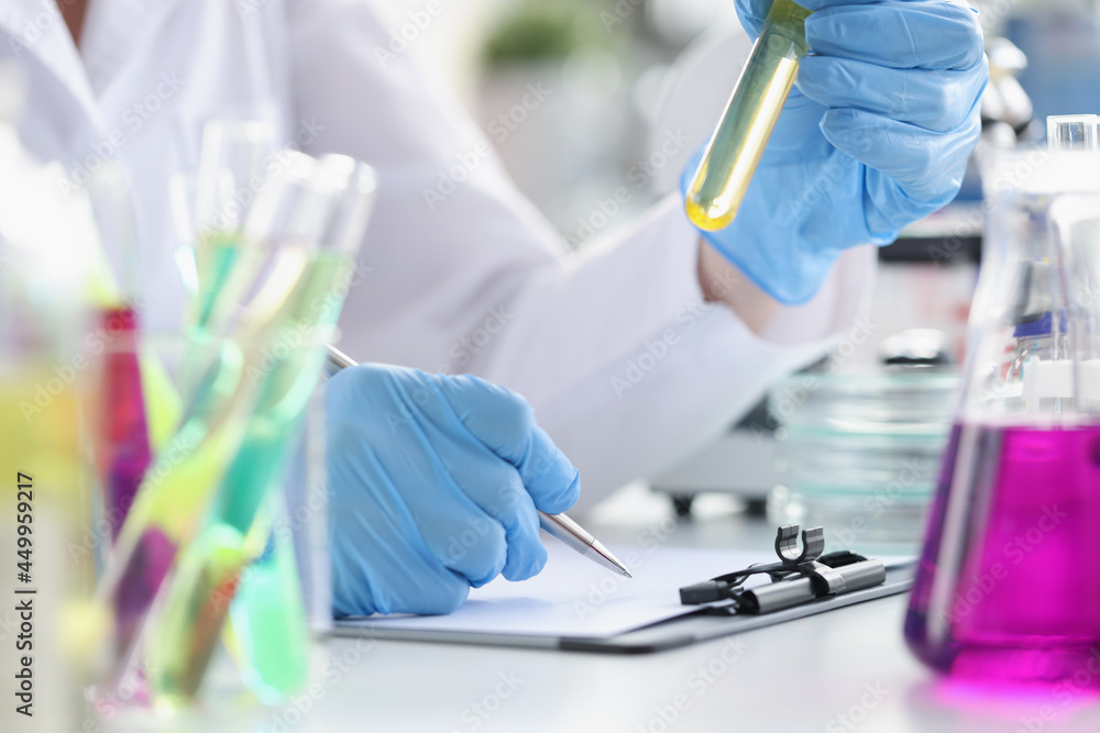Fototapeta premium Researcher records data obtained from chemical experiment in laboratory