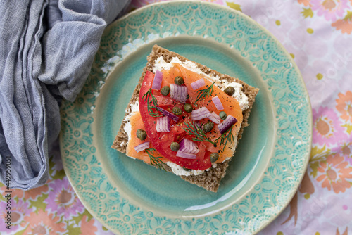 Bild auf Leinwand Top View of a Delicious Breakfast/Brunch of Lox Salmon Toast with Capers, Tomatoes, Dill, Red Onion and Cream Cheese