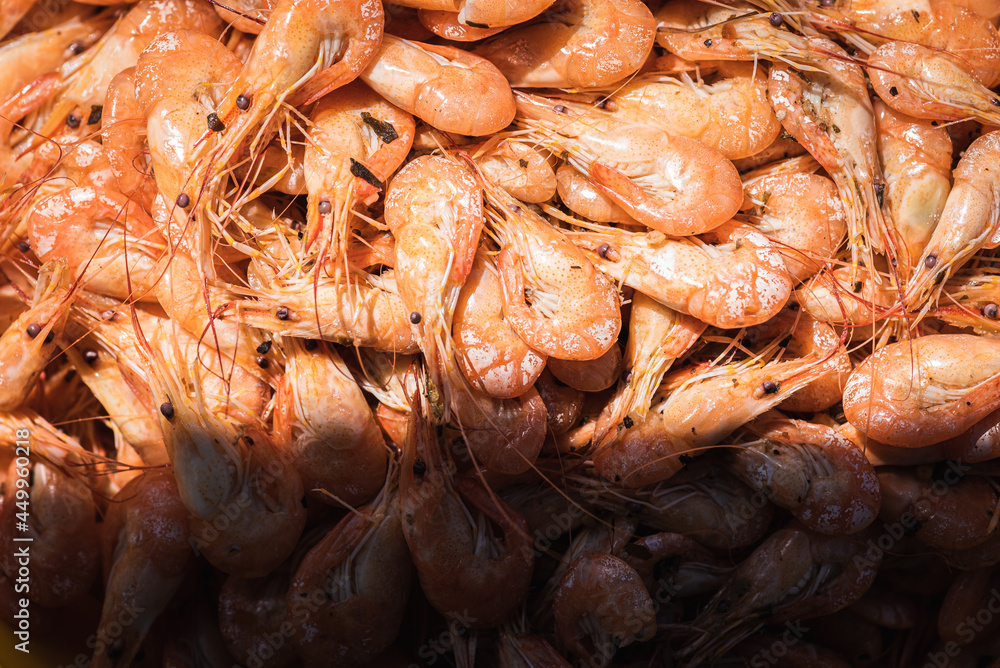 Boiled shrimp unpeeled in a yellow bowl bowl on a gray-brown wooden surface, light shadow, sunlight. Lots of shrimp in a bowl. Shrimp close-up. Top view with space for text. Banner Boiled shrimp unpeeled in a yellow bowl bowl on a gray-brown wooden surface, light shadow, sunlight. Lots of shrimp in a bowl. Shrimp close-up. Top view with space for text. Banner