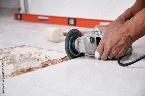 Repairs at home. The hands of the worker repairs the damaged floor