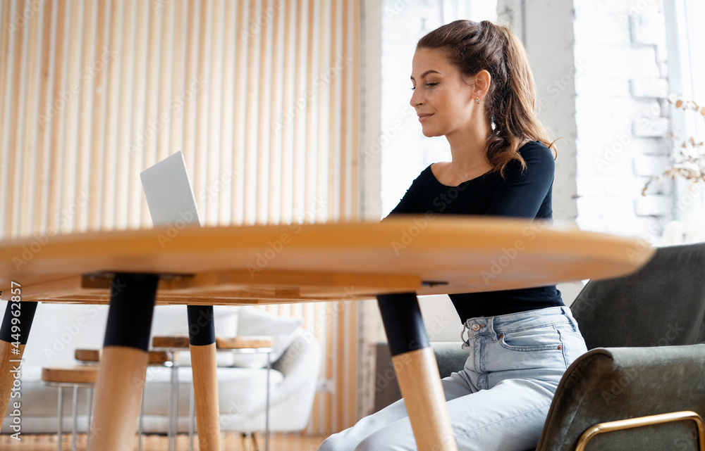 A freelancer communicates with clients by email. A blogger surfs the Internet in a browser. A female student is studying online on a laptop at the university on a wooden table. A freelancer communicates with clients by email. A blogger surfs the Internet in a browser. A female student is studying online on a laptop at the university on a wooden table.