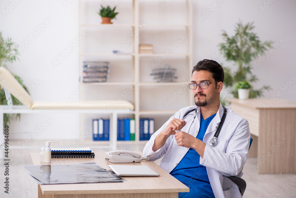 Young male doctor suggesting pills in the clinic