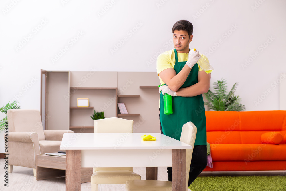 Young male contractor cleaning the house indoors Young male contractor cleaning the house indoors