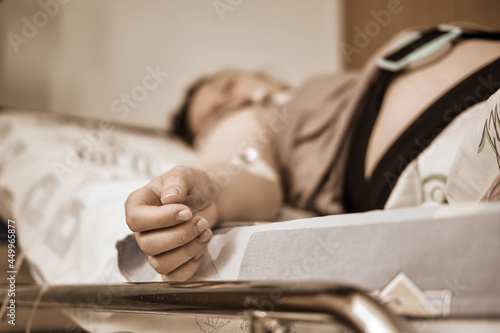 Fotografie A pregnant woman gives birth in a hospital with a drip and a CTG machine