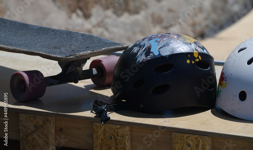 Skate e dois capacetes pousados numa estrutura de madeira construida à mão para acrobacias photo