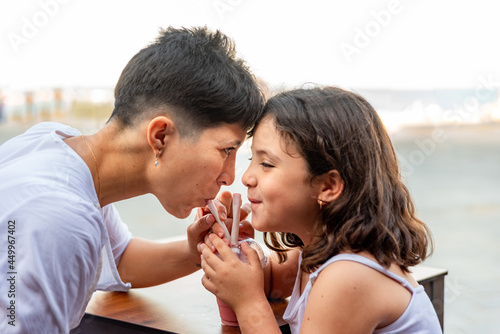 Mother and daughter having fun drinking milkshake