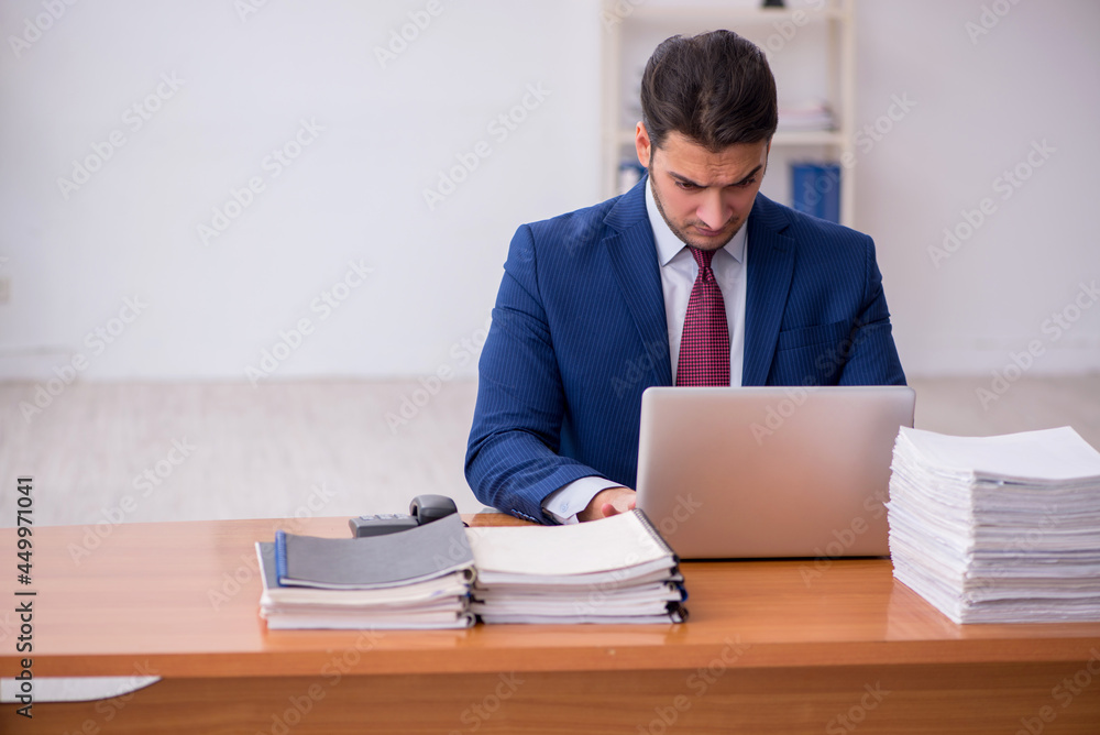 Young businessman and too much work in the office Young businessman and too much work in the office