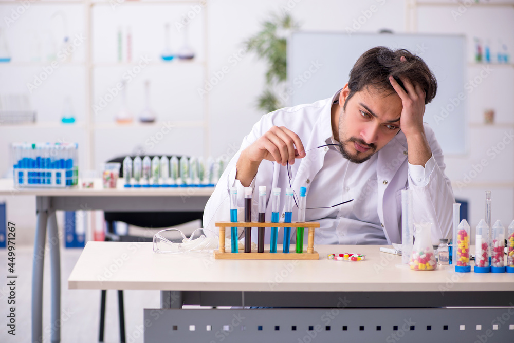 Young male chemist in drugs synthesis concept Young male chemist in drugs synthesis concept