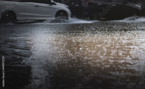 Rain fall and flood in the city with blurry cars as background,selective focus.