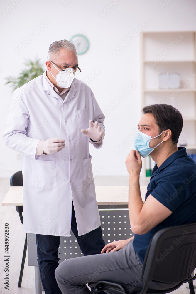 Fototapeta premium Young male patient visiting old male doctor during pandemic