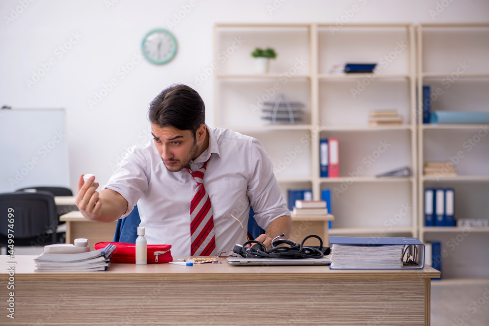 Young male employee suffering at workplace Young male employee suffering at workplace
