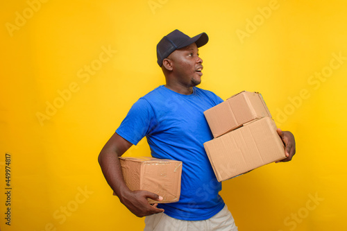 An African delivery or dispatch man carrying boxes and wearing a face cap