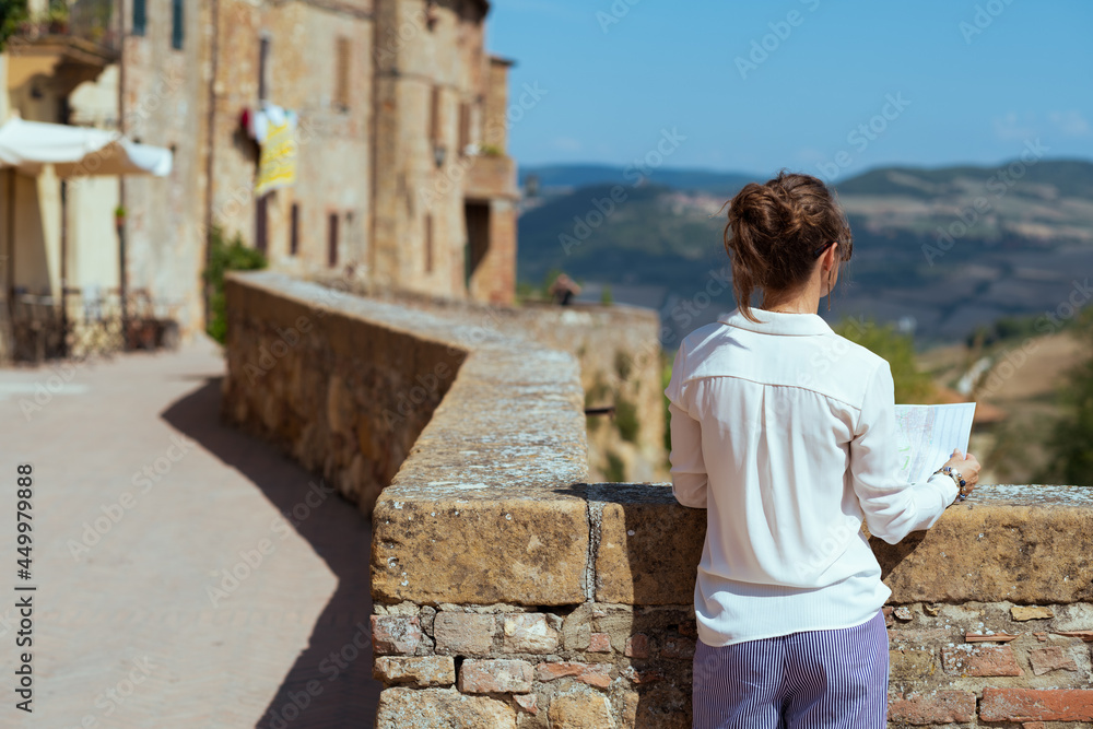 Seen from behind young solo traveller woman in Tuscany, Italy