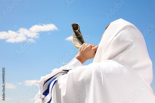 Bild auf Leinwand Jewish man in tallit blowing shofar outdoors