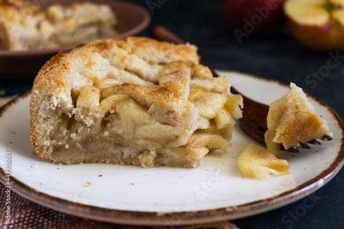 Freshly cut apple pie, with a wooden fork and dark background. Super close up.