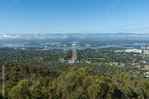 View from Mount Ainslie behind Australian War Memorial Museum building along red sealed ANZAC Parade across Molonglo River to parliament buildings photo