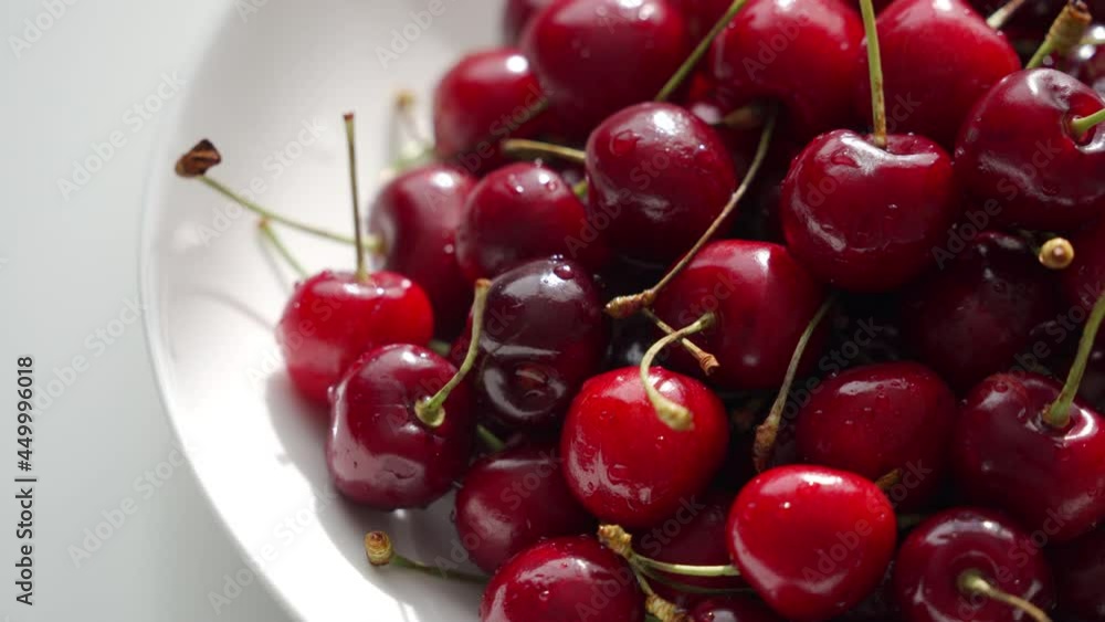 Plate with fresh red cherries on the table in the room on a summer sunny day. High quality 4k footage Plate with fresh red cherries on the table in the room on a summer sunny day. High quality 4k footage