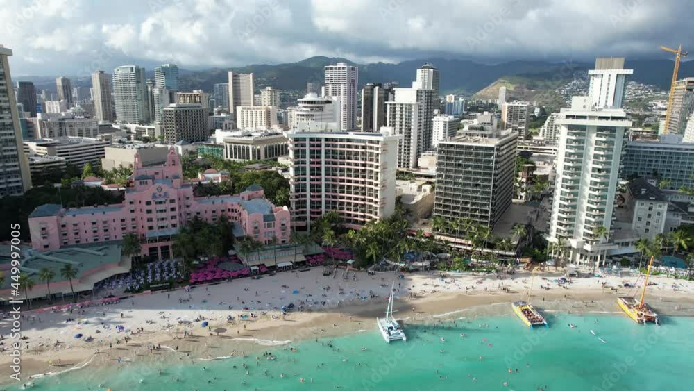 A wide aerial 4k drone shot reveals luxury tropical beach front hotels and families enjoying vacation before gliding closer in. A wide aerial 4k drone shot reveals luxury tropical beach front hotels and families enjoying vacation before gliding closer in.
