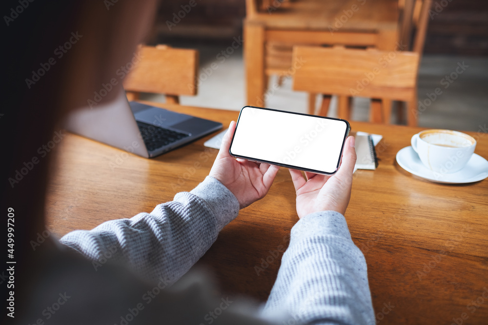 Mockup image of a woman holding mobile phone with blank white desktop screen Mockup image of a woman holding mobile phone with blank white desktop screen
