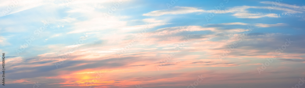 Obraz premium Beautiful sky with clouds at sunset, panoramic big shot. Background from the cloudy sky. Long and stretched clouds in the sky. Blue sky with long clouds for background.