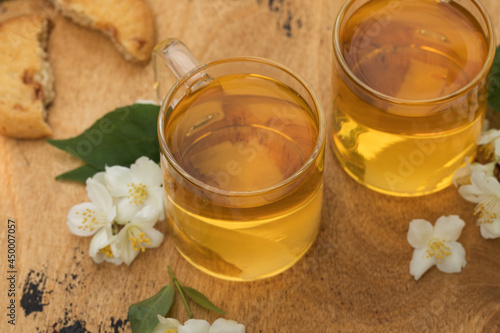 Green Chinese tea with jasmine in a mug with jasmine flowers.