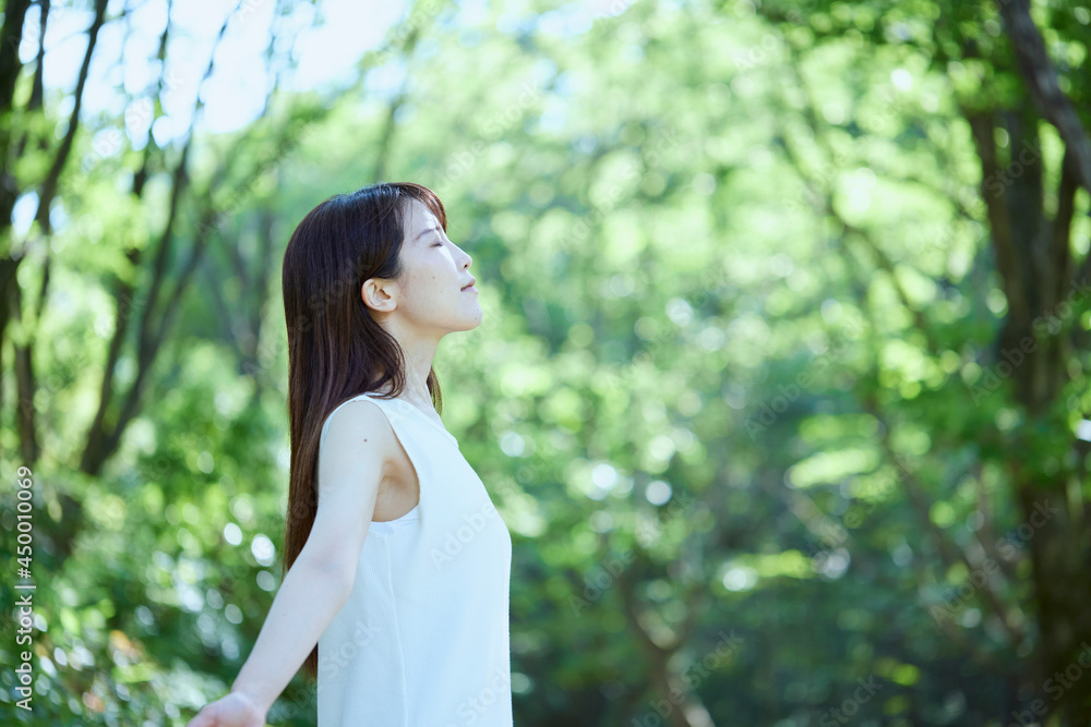 森の中でリラックスする若い日本人女性 森の中でリラックスする若い日本人女性