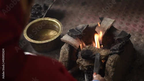 A indian woman preparing clay stove for food selective focus.