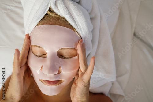 Woman laying in bed wearing a face mask