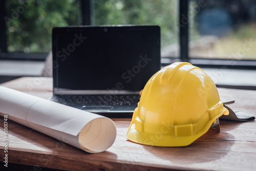 Yellow hard safety helmet hat for safety project of workman as engineer on together joining concept at construction site background.