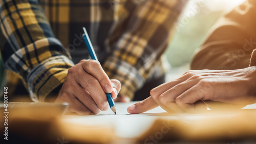 Engineering people architect meeting and pointing at drawings design project discussion working with partner and engineer tools concept at construction site in the office.