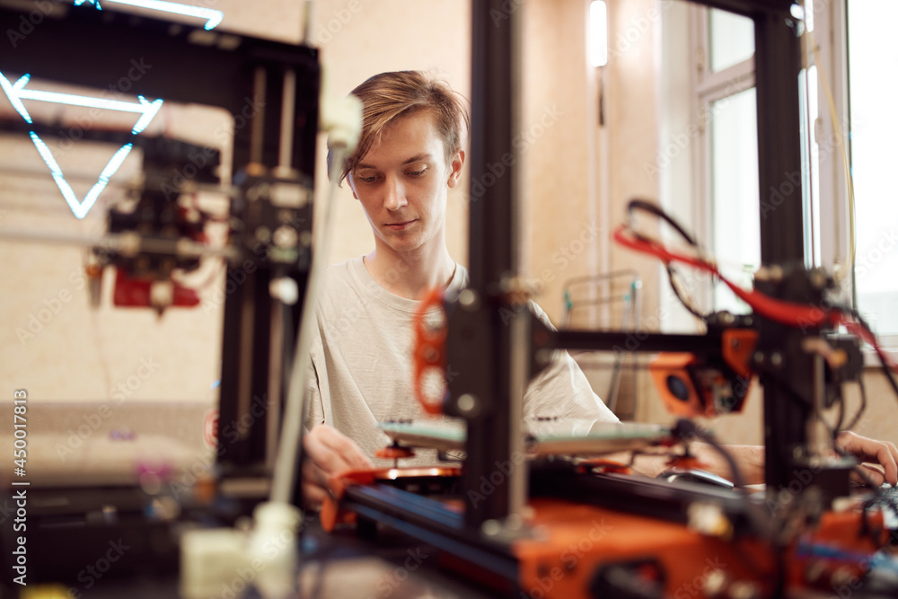 Young man working at laptop. 3d printing concept Young man working at laptop. 3d printing concept