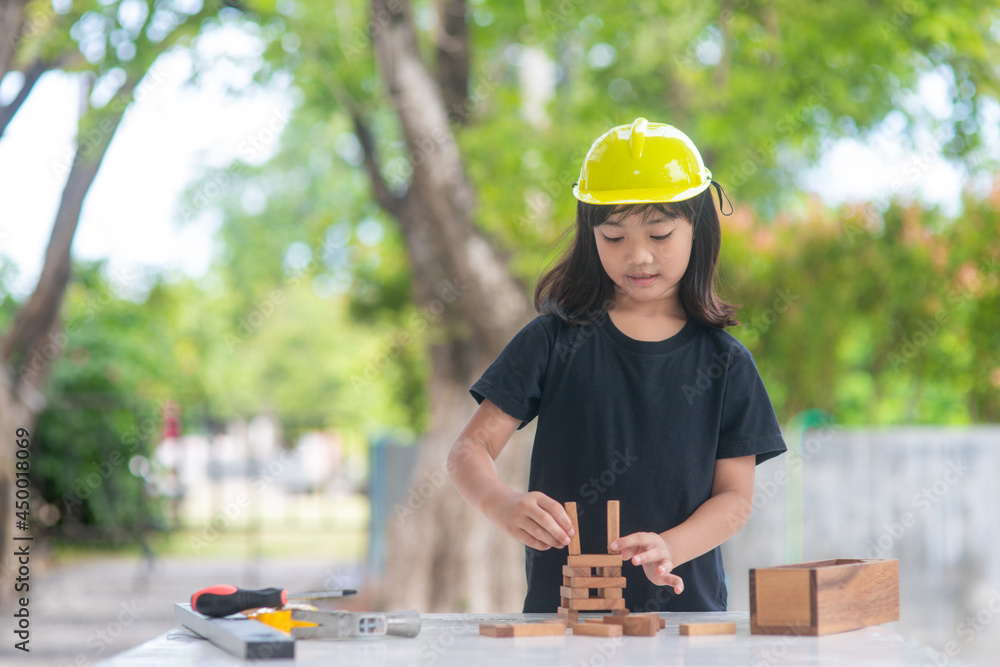 Asian girl children playing as an engineer helmet are smiling and happy on weekends. Asian girl children playing as an engineer helmet are smiling and happy on weekends.