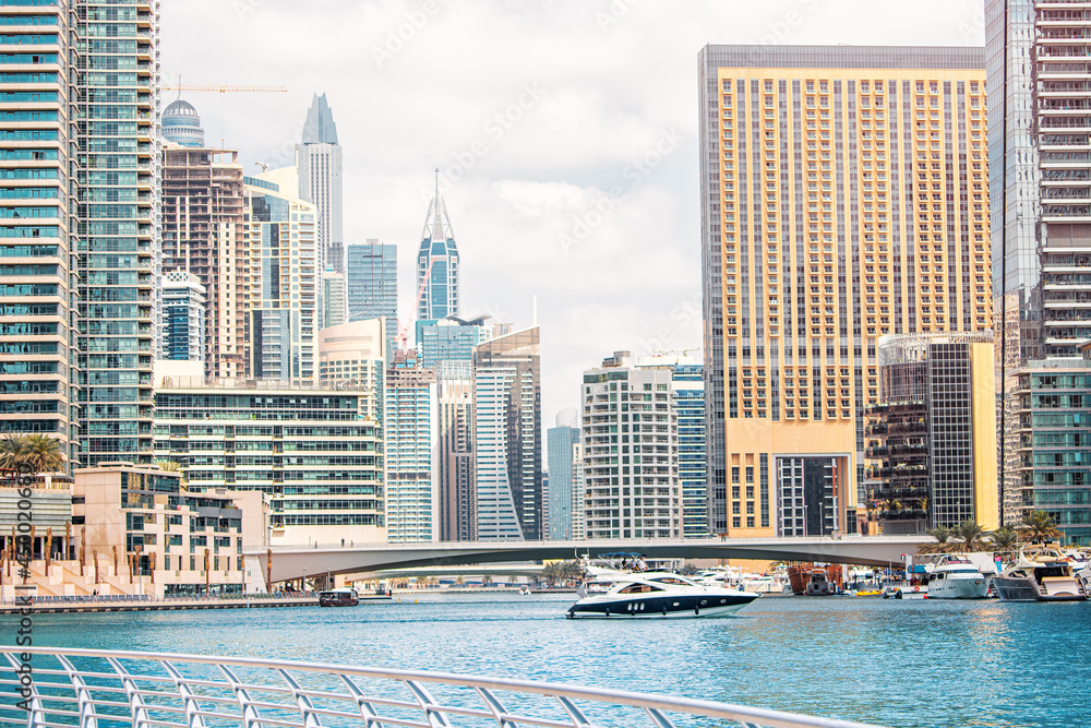 Fototapeta premium Scenic view of a Dubai Marina district with sea harbour and skyscrapers. Development and real estate investment