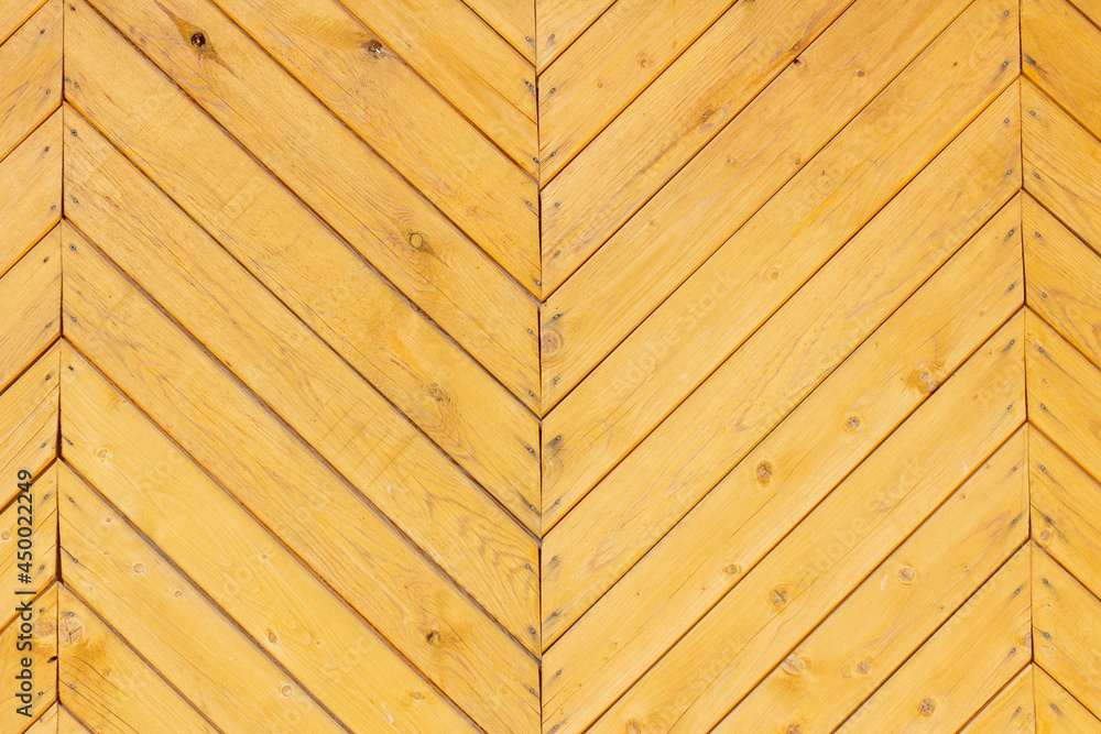 Fototapeta premium Wooden herringbone background.A fragment of an old wooden gate.