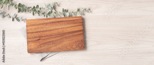 Wood cutting board on linen napkin on wooden background