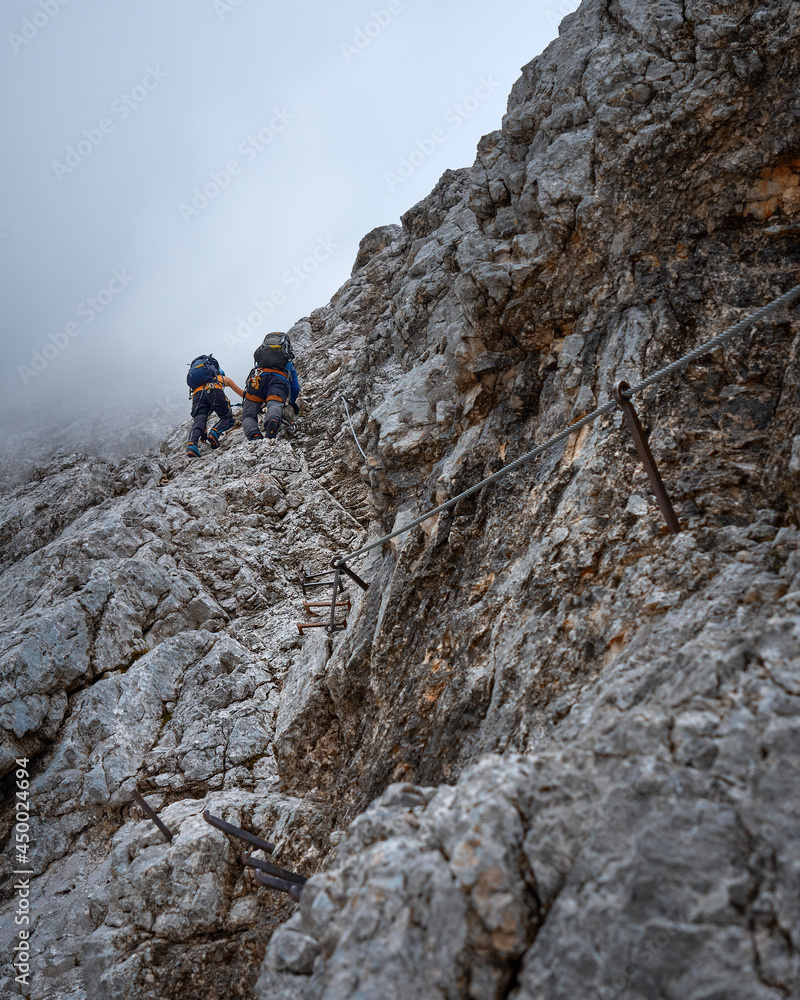 climbing couple in the Höllental via ferrata on their way to the Zugspitze, top of Germany climbing couple in the Höllental via ferrata on their way to the Zugspitze, top of Germany