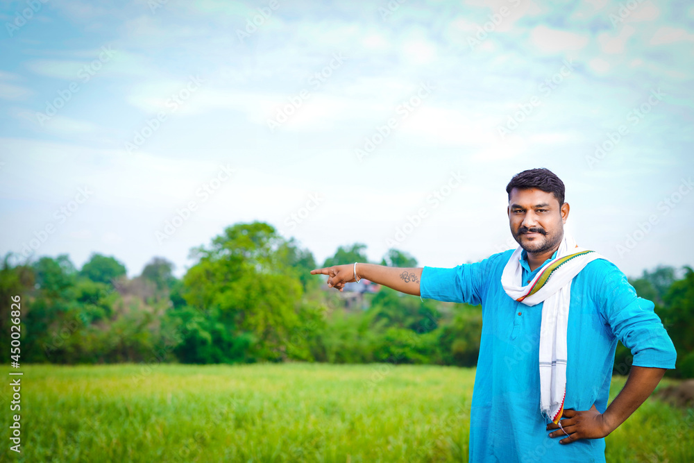 Happy young indian farmer showing hand at sugarcane field (1)